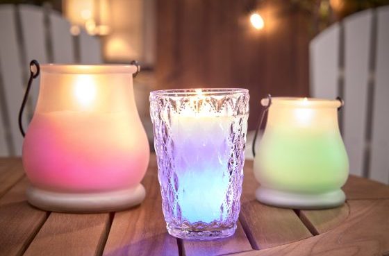 Line up of lit candles on wooden table