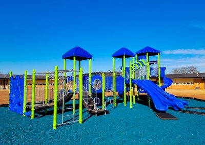 blue and green playground with blue rubber mulch