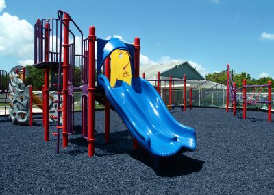 blue and red playground with black rubber mulch